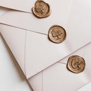 Three envelopes arranged with custom wax seals, creating a sophisticated and classic look.