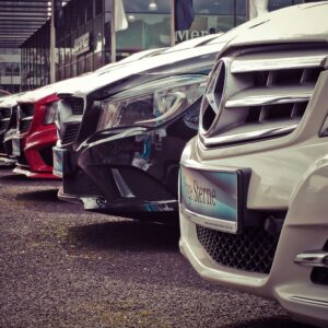 Luxury cars lined up at an outdoor dealership, showcasing sleek designs.
